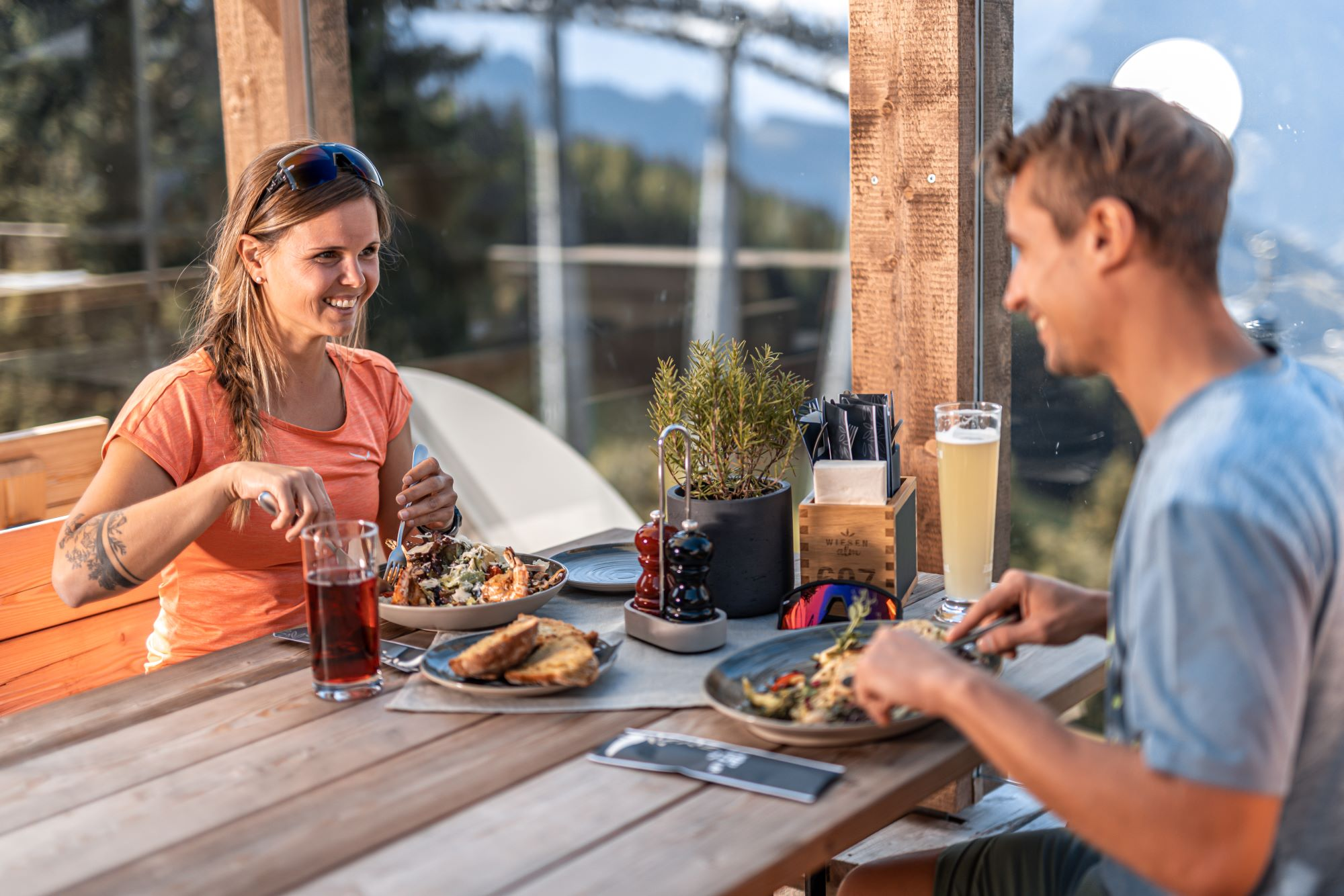 Paar genie&szlig;t eine Mahlzeit auf der Terrasse einer Bergh&uuml;tte in Gerlos