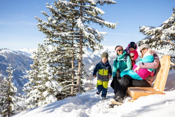 Familie auf einer Bank im Schnee für Snowtrex in Gerlos