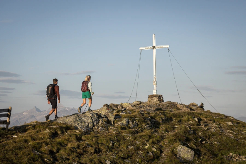 Wanderer am Gipfelkreuz beim Kreuzjoch
