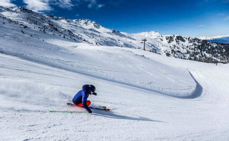 Skifahrer auf der Piste bei den Chalets in Gerlos