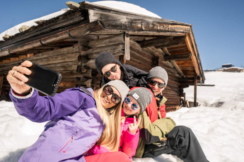 Gruppe macht ein Selfie vor einem Chalet für TUI in Gerlos